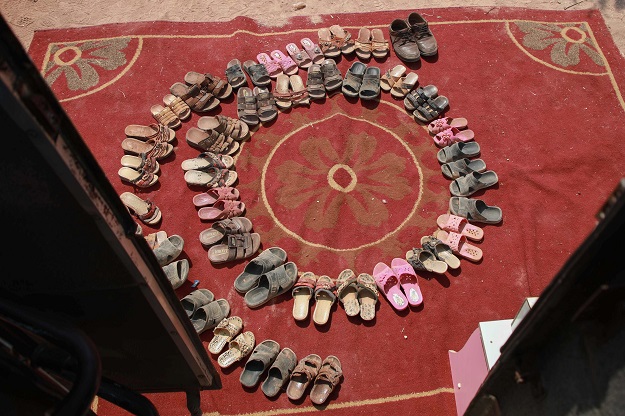The shoes of displaced Syrian children are left outside the bus (Photo: AFP)