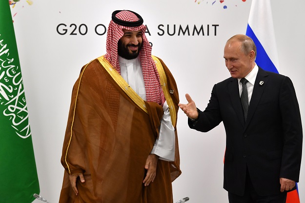 FILE PHOTO: Russia's President Vladimir Putin gestures toward Saudi Arabia's Crown Prince Mohammed bin Salman. PHOTO: REUTERS