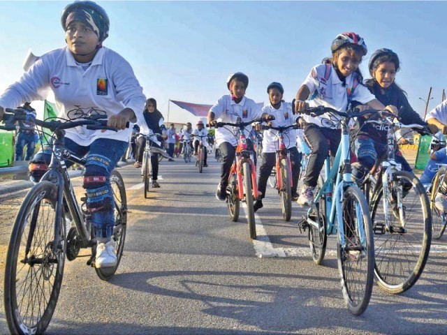 Girls participate in a bicycle race near Do Darya, organised by Lyari Girls’ Cafe to celebrate the International Day of the Girl Child.  PHOTOS: ONLINE/INP