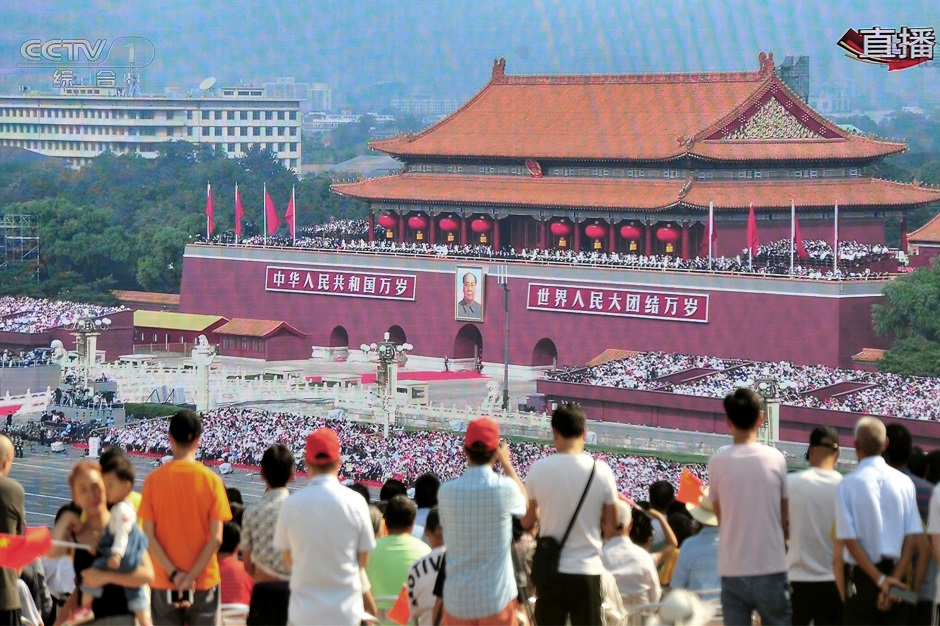 People watch on a giant screen broadcasting the military parade. PHOTO: Reuters