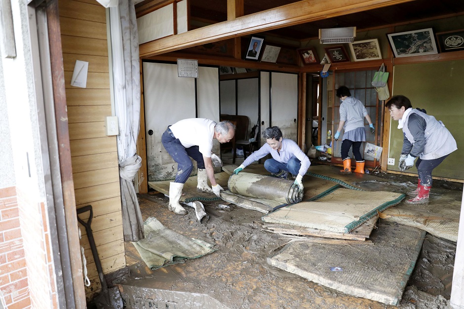 Local residents try to clean inside a house at an area flooded by Typhoon Hagibis. PHOTO: REUTERS