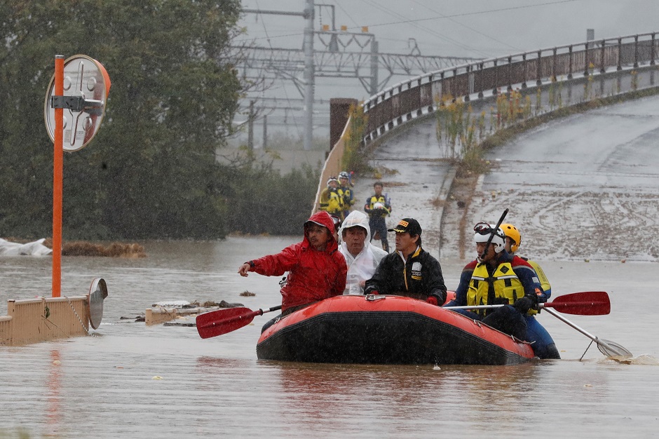 Emergency personnel paddle across floodwaters during search and rescue operations in the aftermath of Typhoon Hagibis. PHOTO: AFP