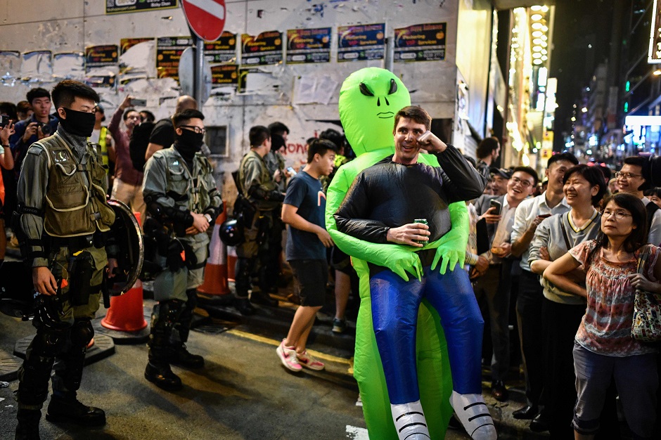 A Halloween reveller stands before a line of policemen in the Lan Kwai Fong area in Hong Kong on October 31, 2019. PHOTO: AFP