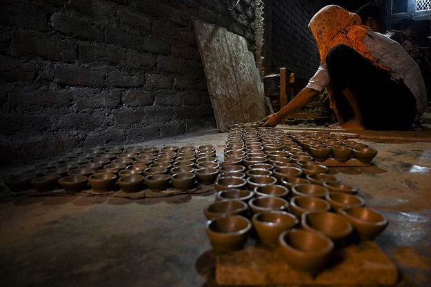 A potter prepares 'diyas' (earthen lamps) inside a house ahead of the upcoming Hindu festival Diwali. PHOTO: AFP