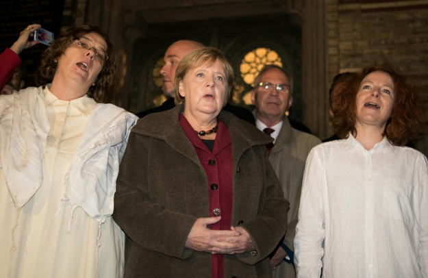 German Chancellor Angela Merkel sings with members of the Jewish community at a vigil outside Berlin's main synagogue. PHOTO: AFP