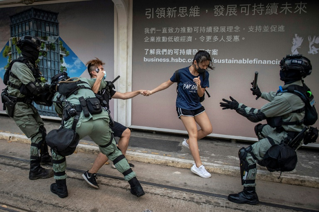 Police chased down a couple wearing facemasks in the Central district in Hong Kong. PHOTO: AFP