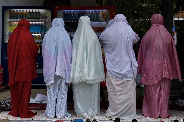 Indonesian migrant workers praying at Victoria Park in Hong Kong (Photo: AFP)