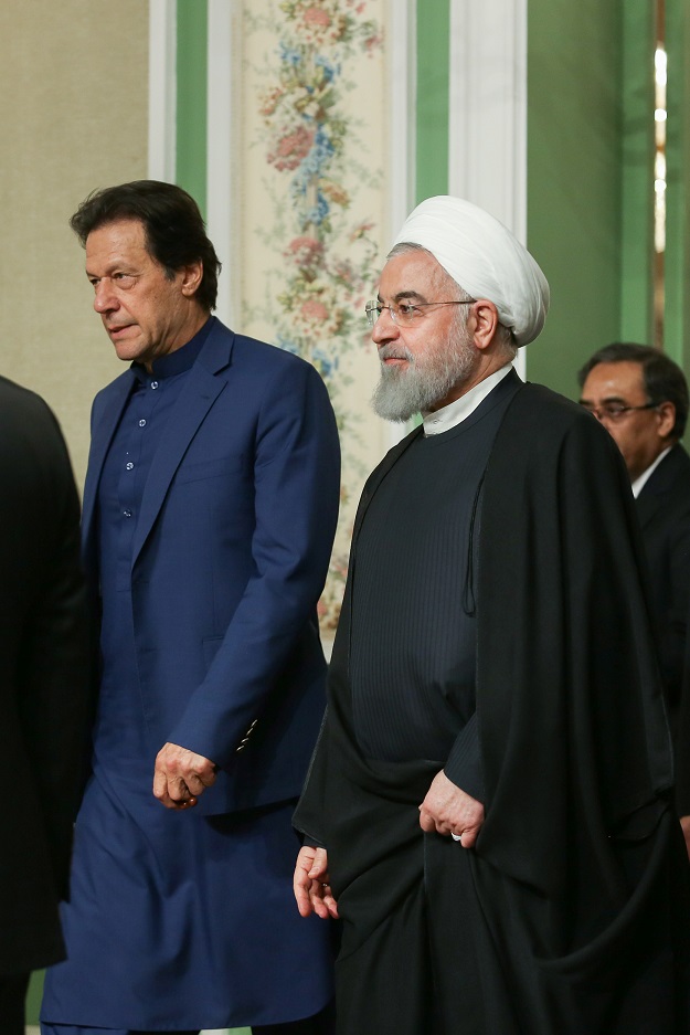 Iranian President Hassan Rouhani walks with Pakistani Prime Minister Imran Khan as they attend a press conference in Tehran. PHOTO: REUTERS