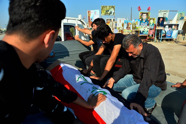 Iraqis mourn over the coffin of a demonstrator, reportedly killed the day before during anti-government protests in the eastern city of Diwaniya, during his funeral in the central holy shrine city of Najaf on October 26, 2019 (Photo: AFP)