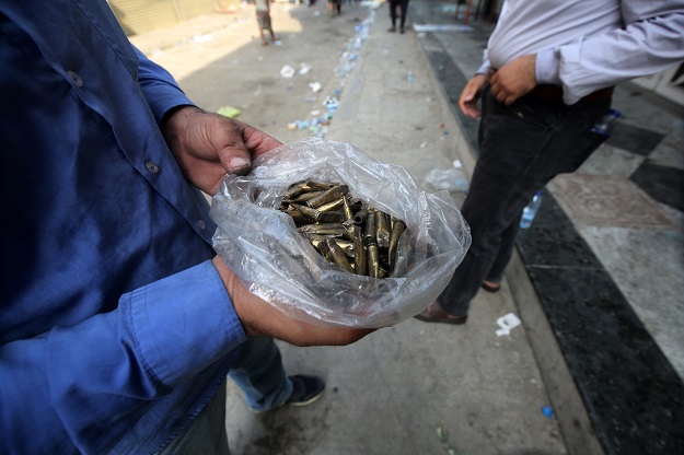 A protester holds in his hands a plastic bag holding casings of live rounds reportedly fired by riot police during clashes amidst demonstrations (Photo: AFP)