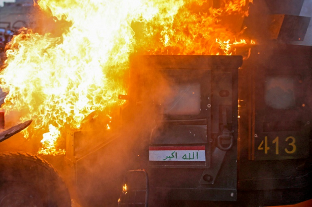 A riot police vehicle burns during clashes between protesters and the police in Baghdad. PHOTO: AFP