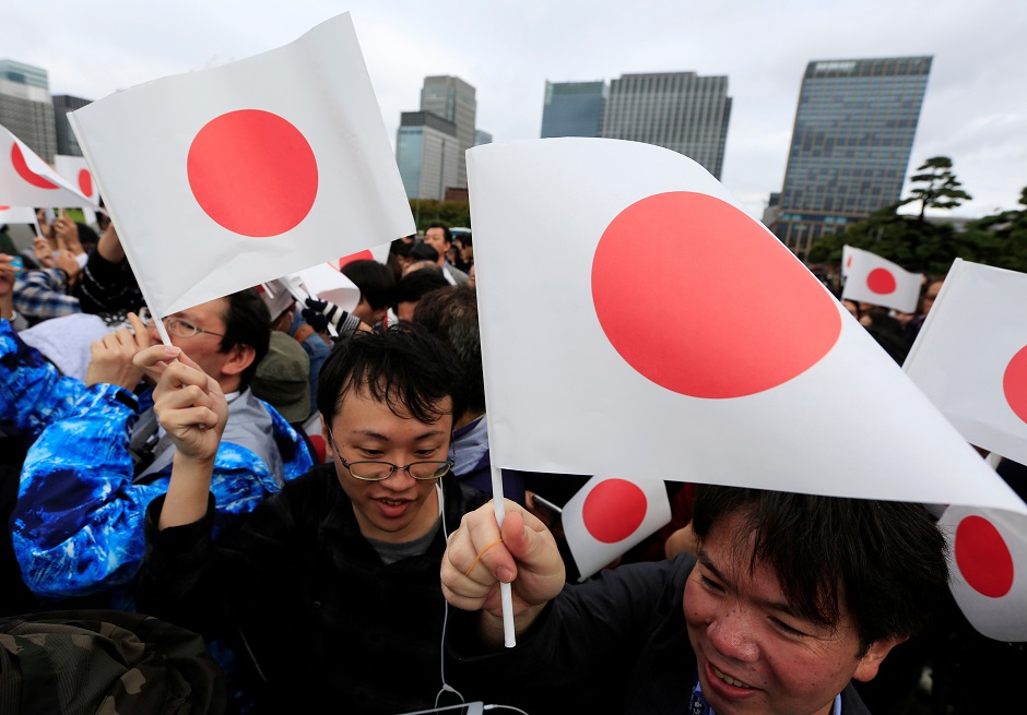 People wave Japanese flags as they gather in front of the Imperial Palace. PHOTO: Reuters