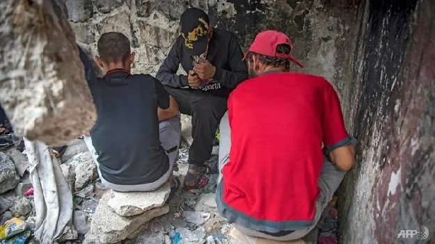 Moroccan addicts smoke heroin in a squat behind a police station in the Moroccan city of M'diq near Tetouan. PHOTO: AFP