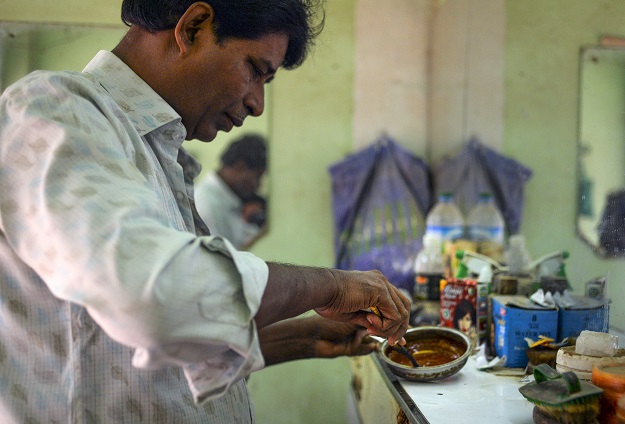 Barber Mohammad Shadat Hossain prepares henna powder to apply on the hair of a client in Dhaka (Photo: AFP)