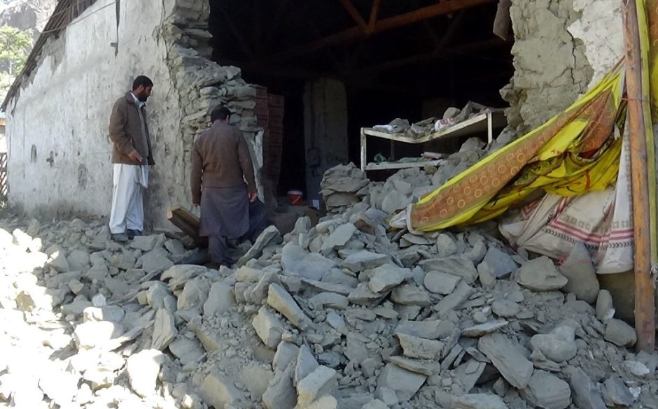 Pakistani residents stand over the rubble of a market building in Chitral on October 27, 2015, a day after it was struck by the earthquake that rocked the country and neighbouring Afghanistan. PHOTO: AFP
