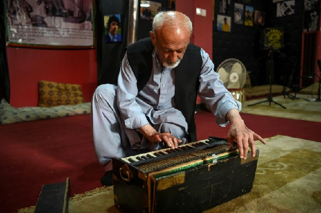 Poet Safiullah Sobat shows the old harmonium that belonged to Afghanistan's Elvis Presley, at the Ahmad Zahir Cultural Centre in Kabul. PHOTO: AFP