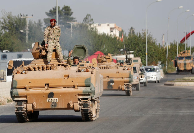 Members of Syrian National Army, known as Free Syrian Army, drive in an armored vehicle in the Turkish border town of Ceylanpinar in Sanliurfa province. PHOTO: Reuters