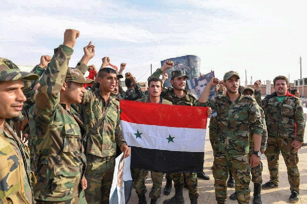 Syrian army troops posing with a national flag. PHOTO: AFP