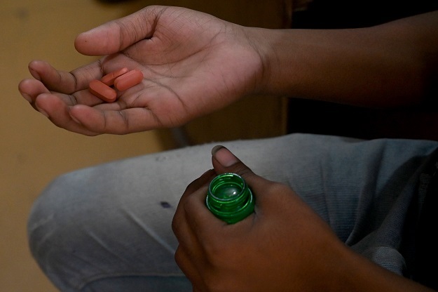 A tuberculosis patient holds his daily dose of medicine at a DOTS (Photo: AFP)