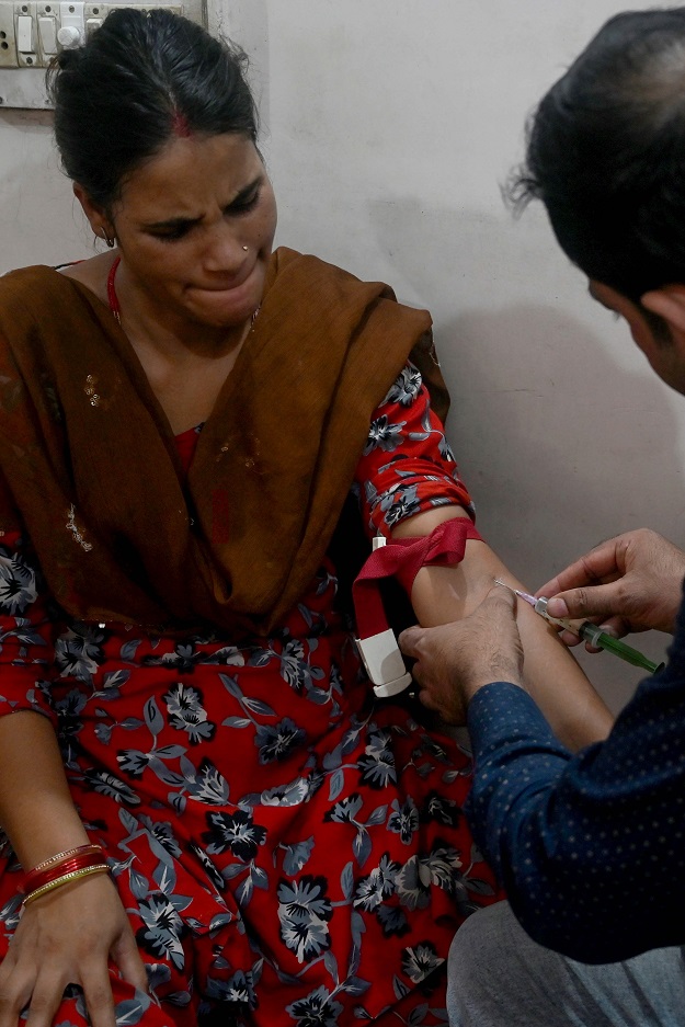 A doctor collects blood sample from a suspected tuberculosis patient at a DOTS (Photo: AFP)