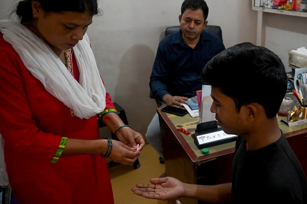 A tuberculosis patient is given his daily dose of medicine by a nurse at a DOTS Centre in New Delhi (Photo: AFP)