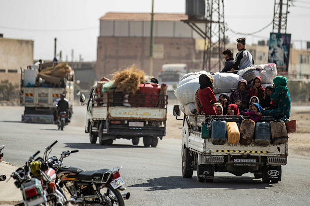 Displaced Syrians sit in the back of a pick up truck as Arab and Kurdish civilians flee amid Turkey's military assault on Kurdish-controlled areas in northeastern Syria, on October 11, 2019 in the Syrian border town of Tal Abyad. PHOTO: AFP