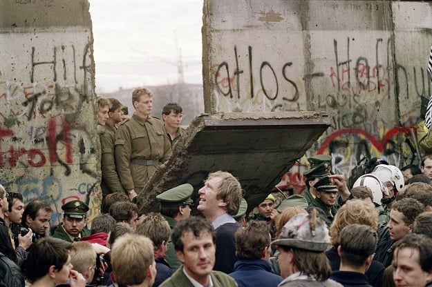 In this file photo taken on November 11, 1989 West Berliners crowd in front of the Berlin Wall early as they watch East German border guards demolishing a section of the wall in order to open a new crossing point between East and West Berlin, near the Potsdamer Square in Berlin (Photo: AFP)