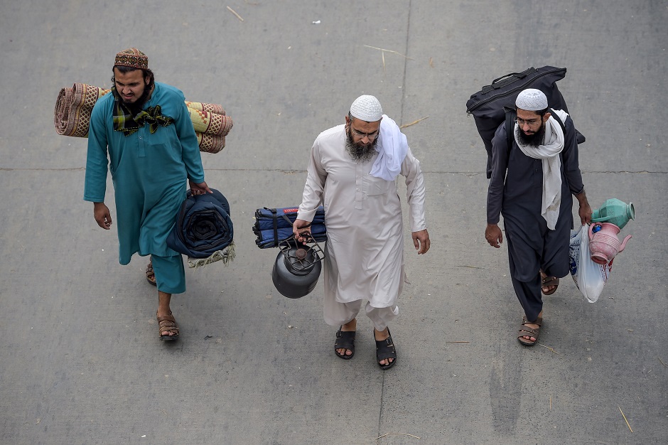 Activists of Islamic political party Jamiat Ulema-e-Islam (JUI-F) carry their belongings as they arrive during an anti-government 