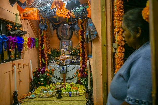A woman looks at offerings for the celebration of the Day of the Dead (Photo: AFP)