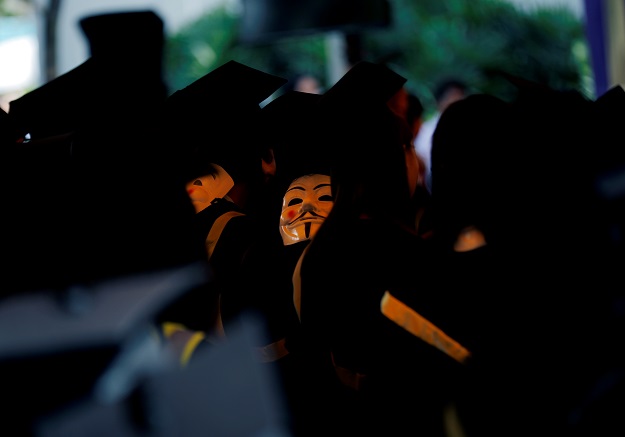 Graduates wearing Guy Fawkes masks attend a graduation ceremony at the Chinese University of Hong Kong. PHOTO: Reuters