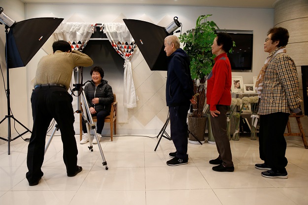 People pose for their fake funeral pictures. PHOTO: Reuters