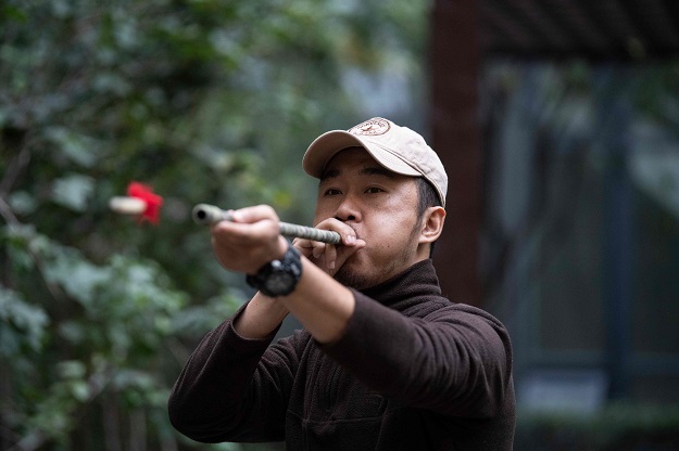 This photo shows pet detective Sun Jinrong testing his blowdart as he prepares to search for a missing cat. PHOTO: AFP
