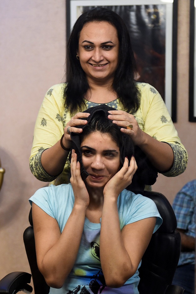 In this picture, transgender beautician Bebo Haider (behind) attends to a customer in her beauty parlour in Karachi. PHOTO: AFP