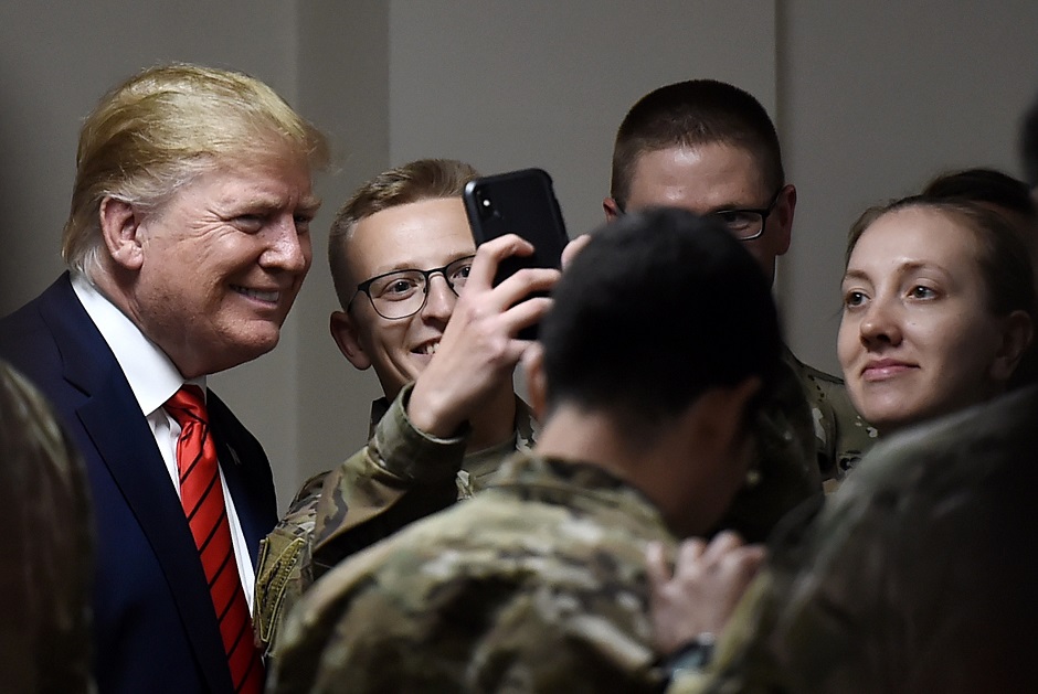 US President Donald Trump poses for selfies during a Thanksgiving dinner with US troops. PHOTO: AFP
