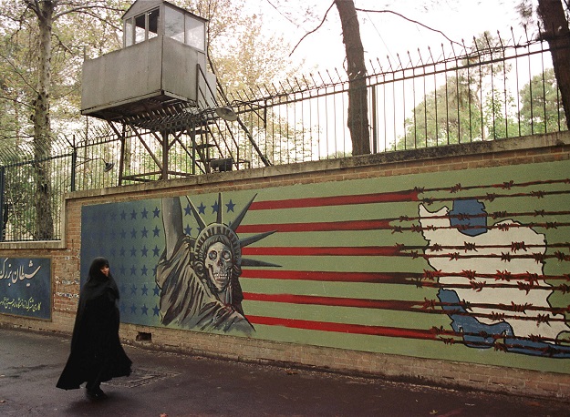 A file photo taken on November 03, 1999 shows an Iranian woman walking past an anti-US mural at the former US embassy in Tehran (Photo: AFP)