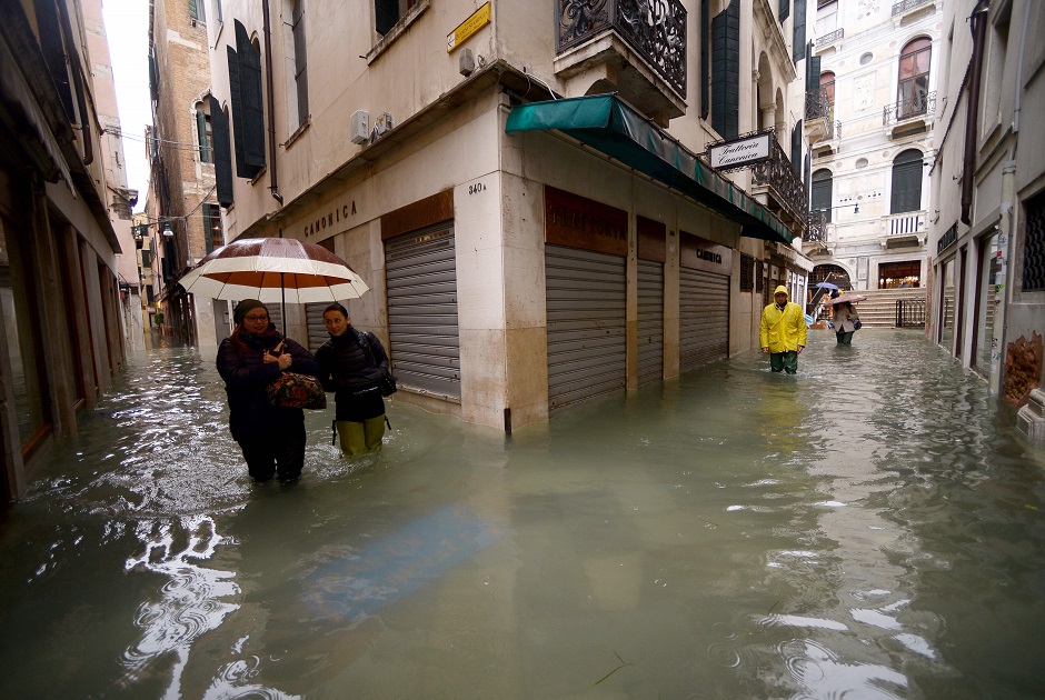 People walk across flooded streets. PHOTO: AFP