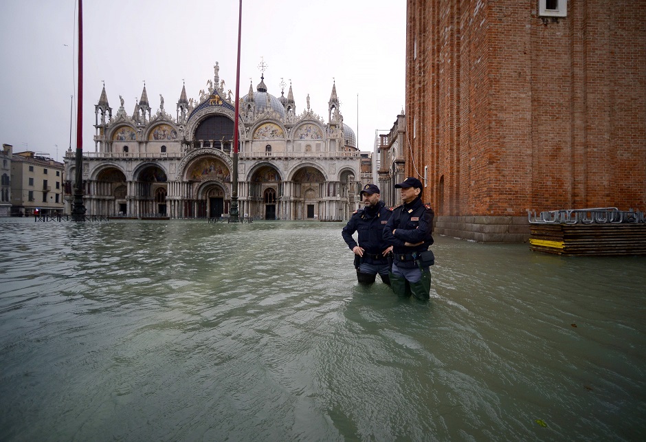 Officers from the Italian National Police (Polizia di Stato) stand in the flooded St. Mark's Square. PHOTO: AFP