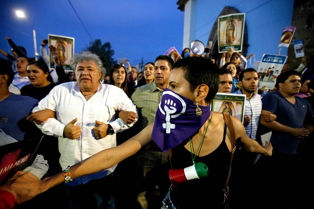 Catholic faithful form human chains near a church in the framework of the International Day for the Eradication of Violence against Women and against abortion in Guadalajara, Mexico. PHOTO: AFP