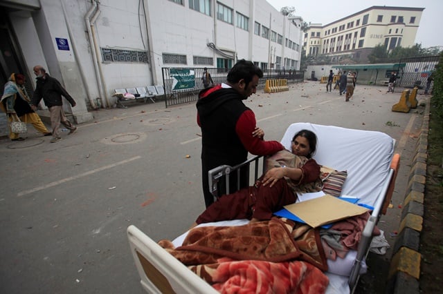 A relative takes care of a patient on a bed after she was taken out of her ward when a group of lawyers stormed the Punjab Institute of Cardiology (PIC) in Lahore, Pakistan December 11, 2019. REUTERS/Mohsin Raza