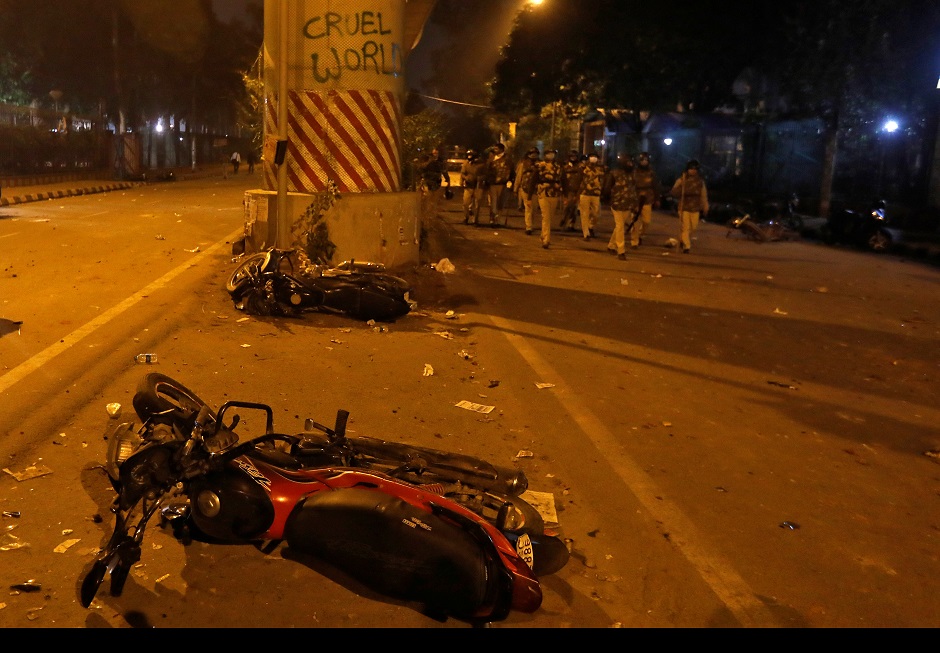 Policemen patrol past damaged motorcycles outside the Jamia Milia University following a protest against a new citizenship law, in New Delhi. PHOTO: REUTERS 