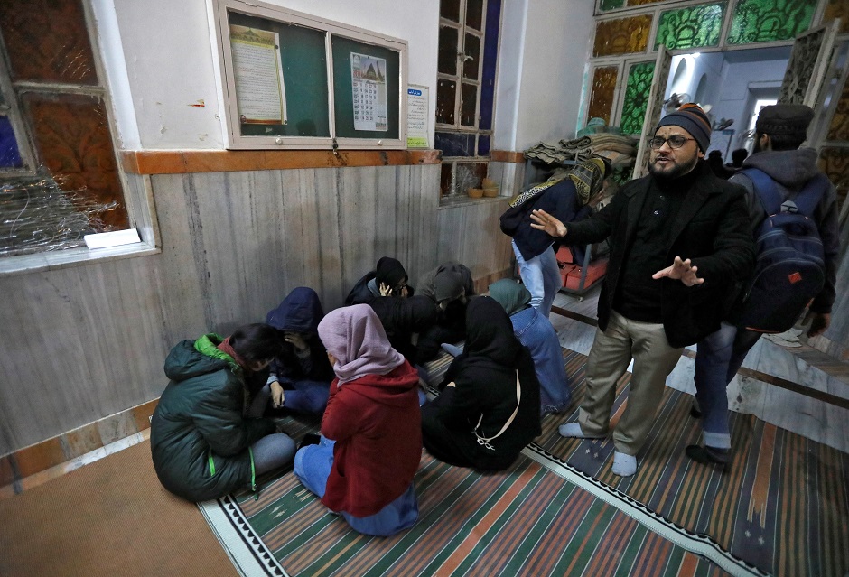 Students of the Jamia Milia University cover their faces as they take shelter in a mosque following a protest against a new citizenship law, in New Delhi. PHOTO: REUTERS 