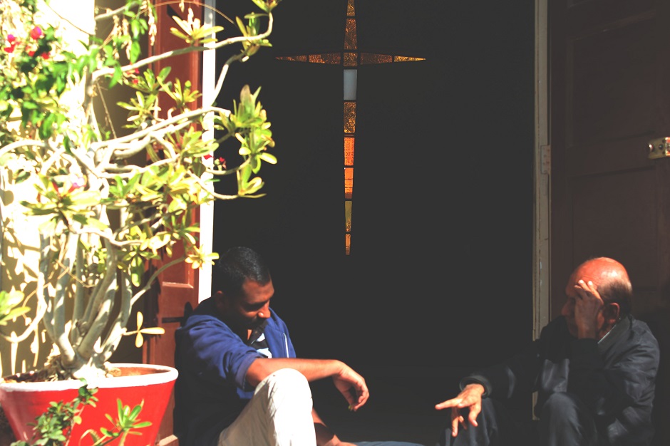 A former addict (left) conversing with a rehab official (right) on the stairs of the chapel