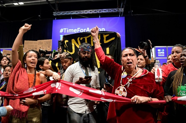 Hundreds of activists protested metres away from negotiations before being forcibly removed. PHOTO: AFP 
