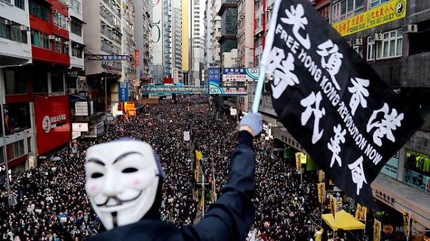 A protester wearing a Guy Fawkes mask waves a flag during a Human Rights Day march organised by the Civil Human Right Front in Hong Kong, December 8, 2019. PHOTO: REUTERS