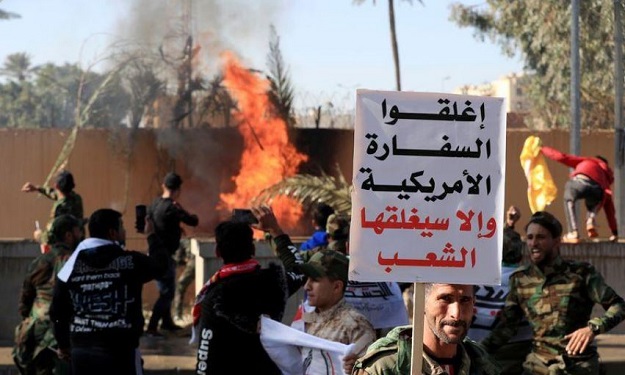 A Hashd al-Shaabi fighter holds a sign reading 