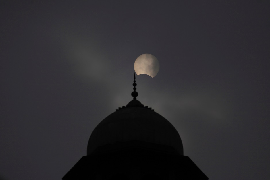 A general view of a mosque with a partial solar eclipse in the background in Lahore, Pakistan. PHOTO: Reuters