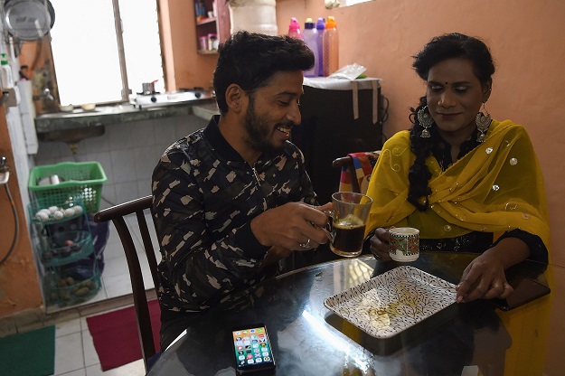 In this picture, freelance make-up artist and a member of LGBT community Asim Nath (L) drinks coffee along with his flatmate transgender freelance make-up artist Tulsi Chandra at their flat in New Delhi. PHOTO: AFP