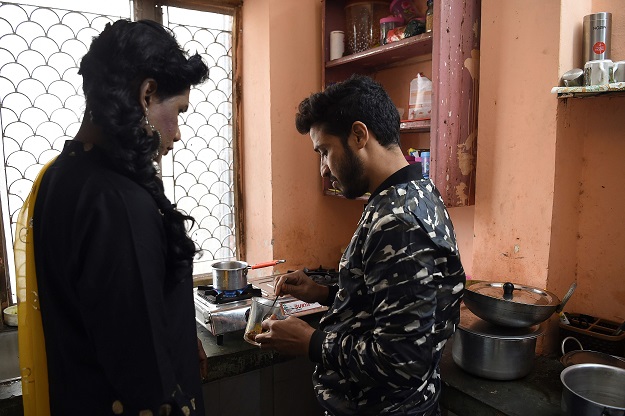 Freelance make-up artist and a member of LGBT community Asim Nath (R) makes a coffee. PHOTO: AFP