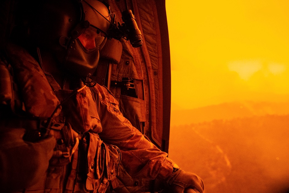  Warrant Officer Class Two Darrel Rowe, from the 5th Aviation Squadron, searches the ground from an Australian Army CH-47F Chinook during the flight to Omeo, Victoria, Australia, to evacuate local civilian residents during Operation Bushfire Assist. PHOTO: REUTERS