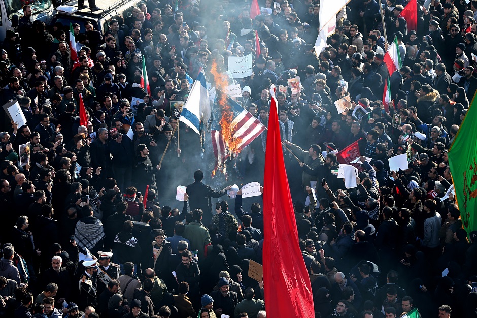 Iranian people burn American and Israeli flags during the funeral procession for Iranian Major-General Qassem Soleimani, head of the elite Quds Force, and Iraqi militia commander Abu Mahdi al-Muhandis, who were killed in an air strike at Baghdad airport, in Tehran, Iran January 6, 2020.PHOTO: REUTERS